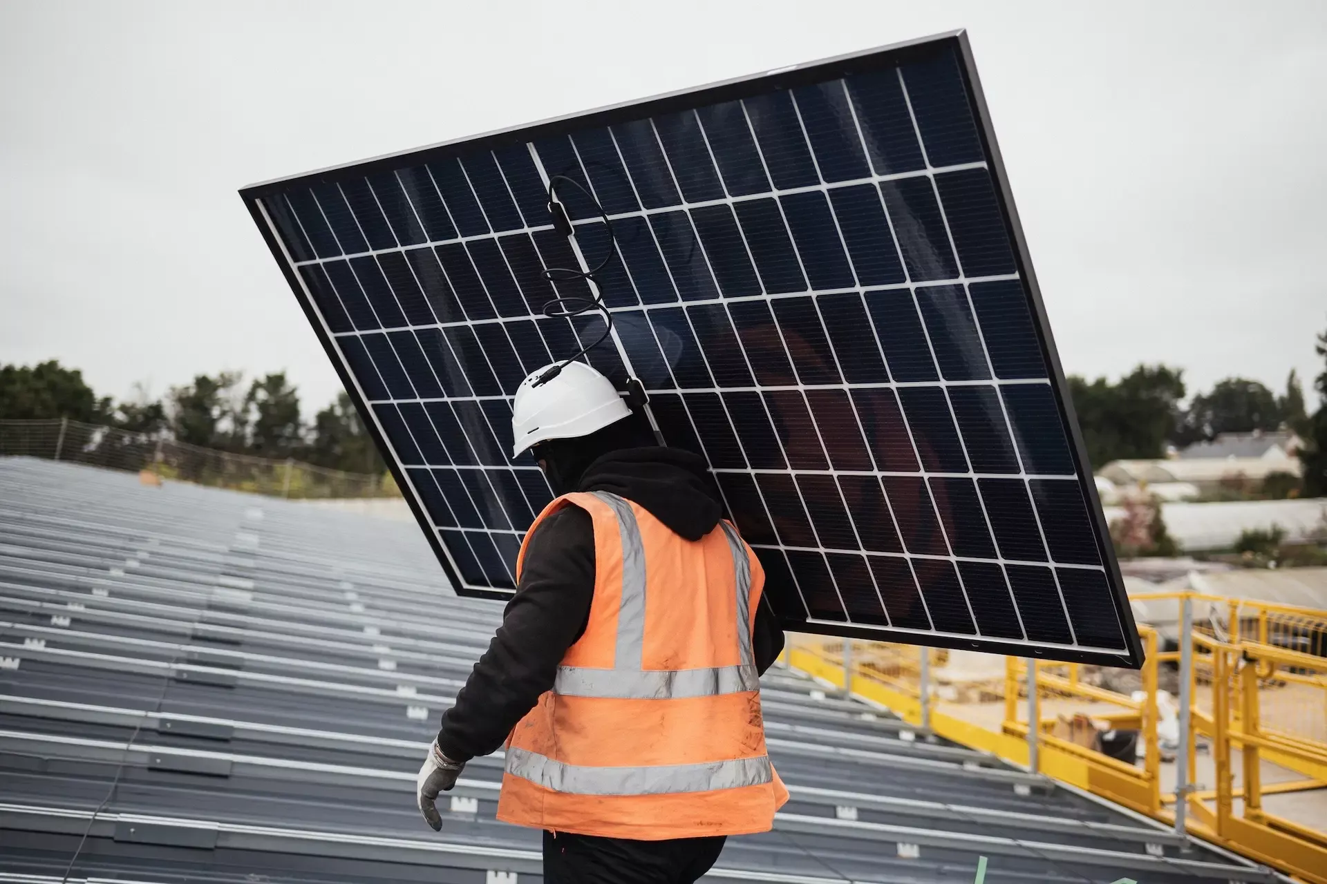 Salarié Triangle Energie en train d'installer un panneau photovoltaïque sur un hangar solaire