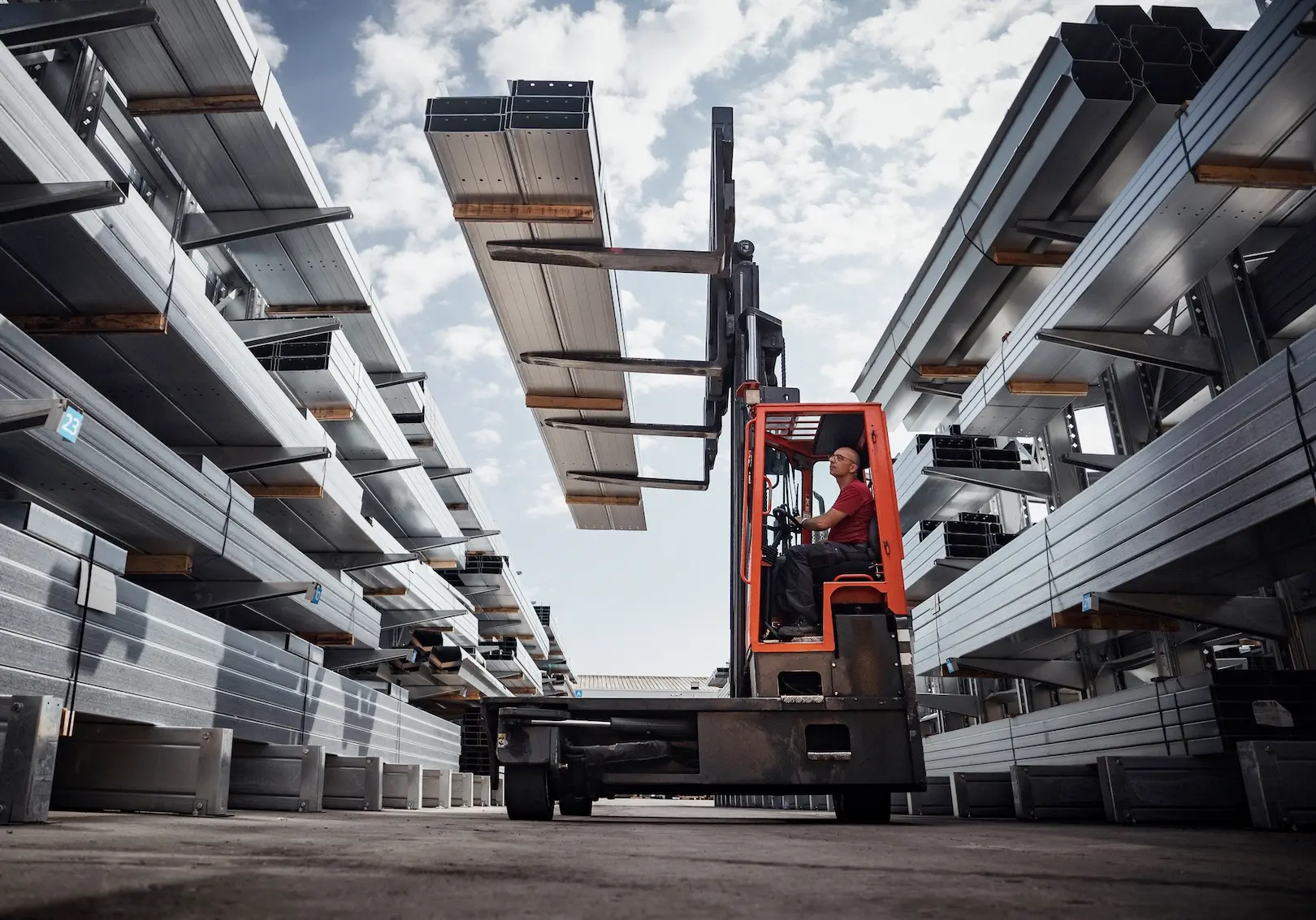 engin de type chariot électrique en train de décharger du matériel industriel pour la réalisation en atelier de bâtiment photovoltaïque